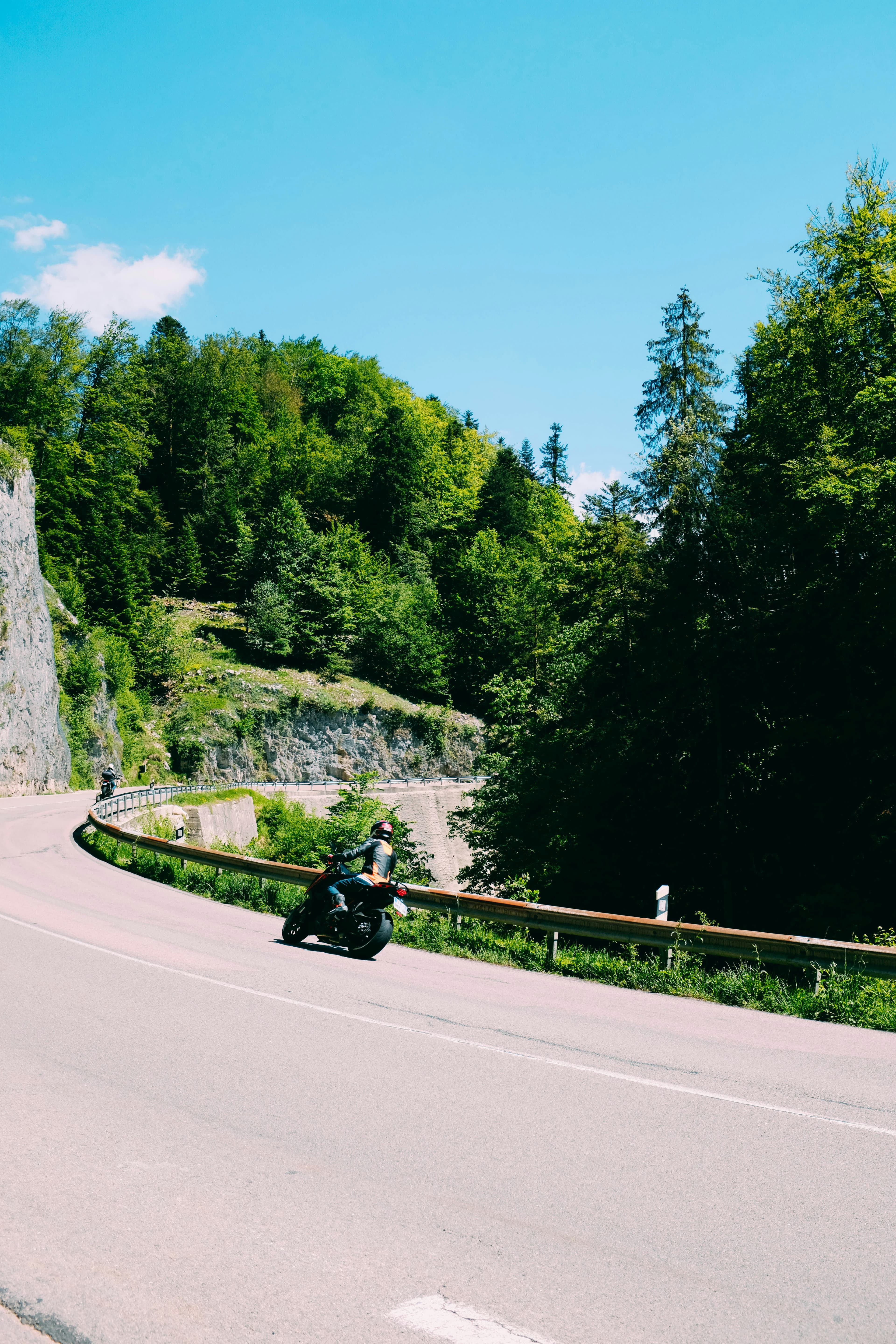 Riders leaning into a bend on a mountain road