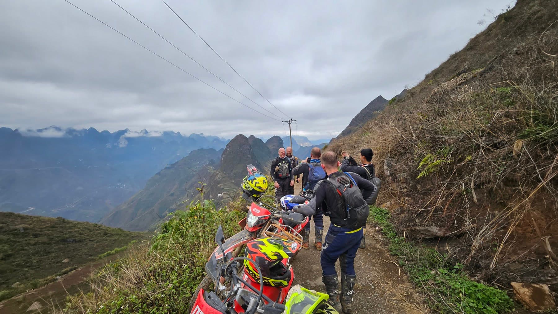A group of motorcycle riders overlooking a pass in Ha Giang