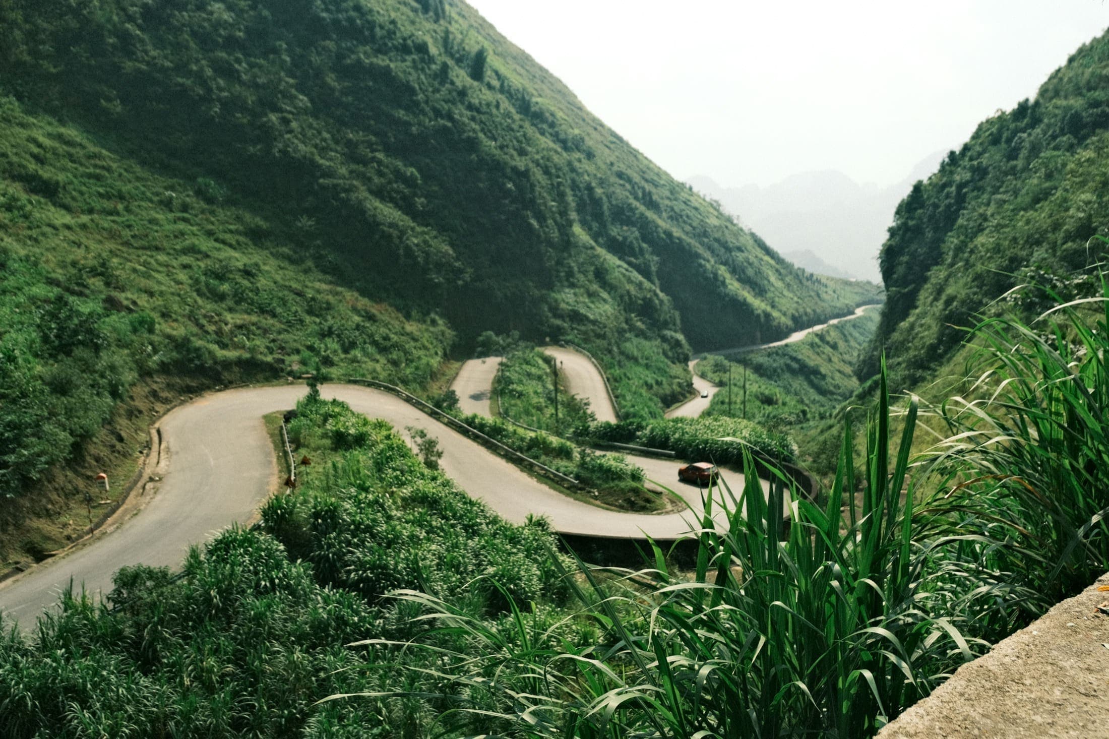 Motorcycle route winding between mountains on a multi-day Ha Giang tour